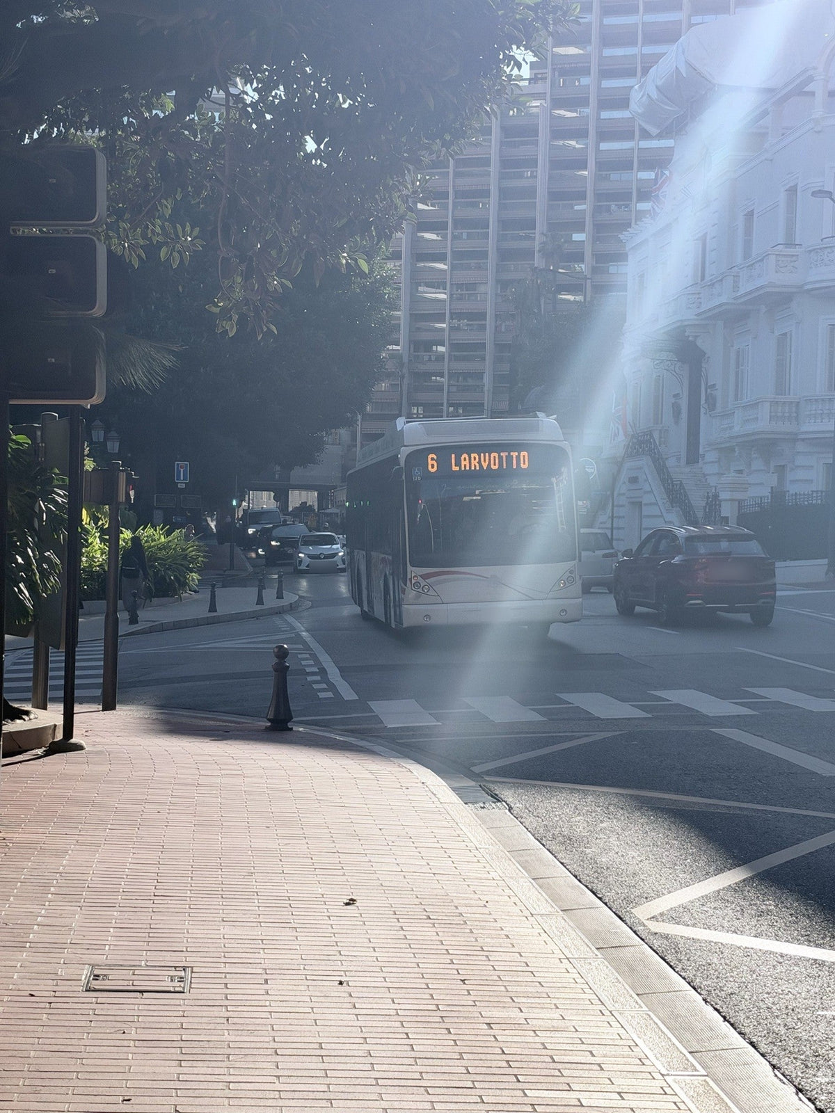 Monaco line 6 bus to Larvotto in morning light, with apartment towers behind