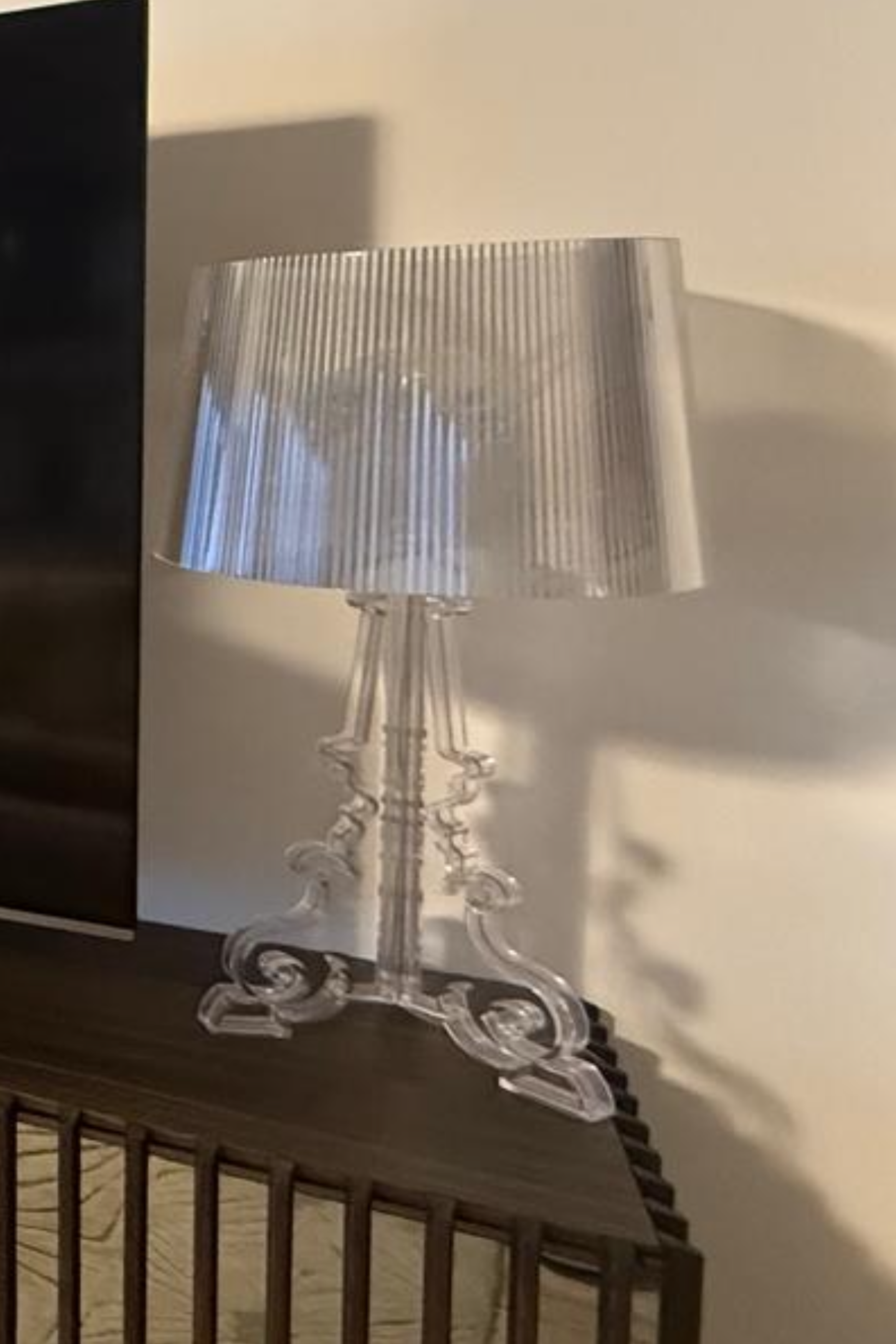 Transparent Kartell Bourgie table lamp with a classic design, showcased on a sleek surface in a stylish setting.