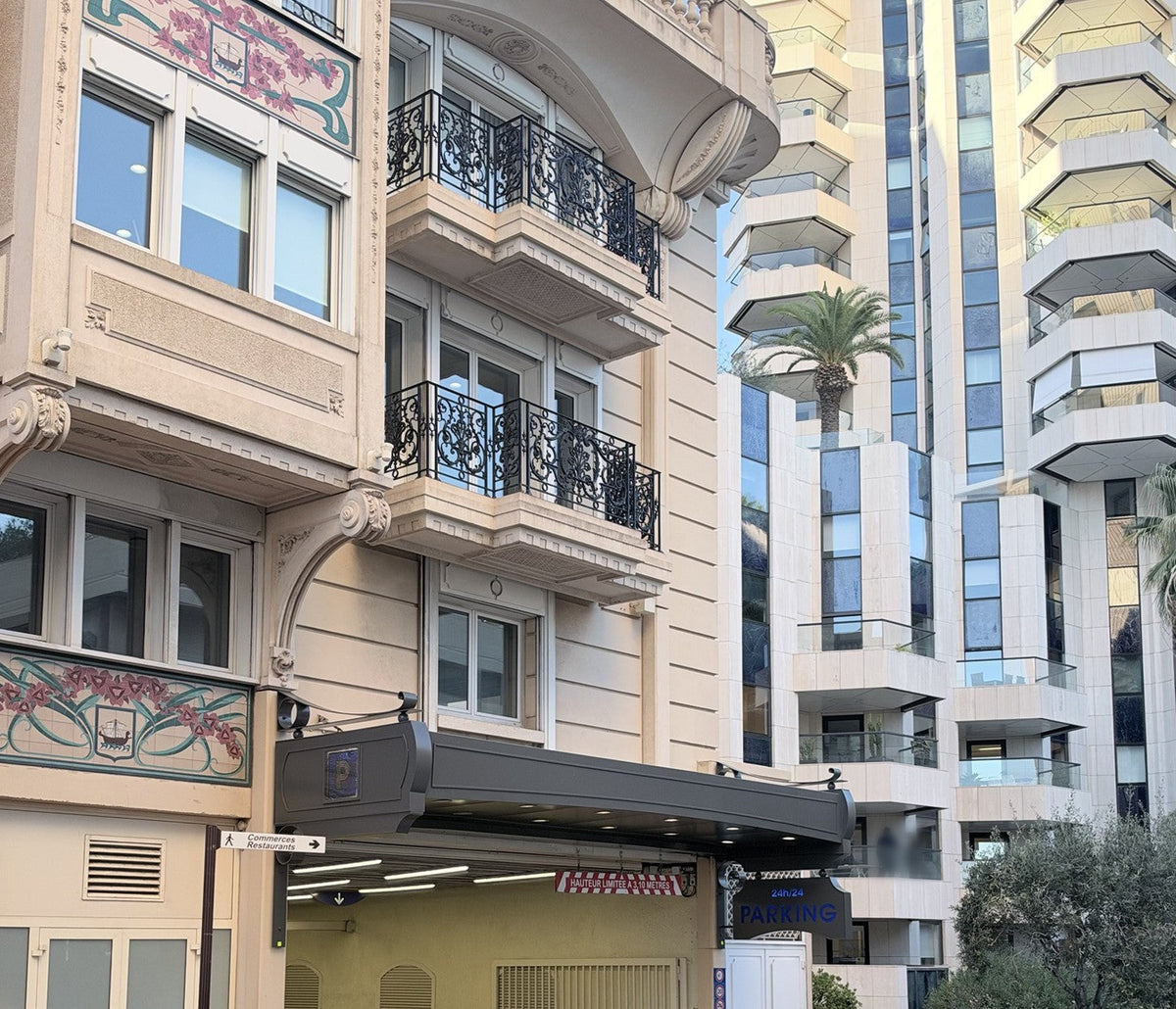 Belle Époque building with floral tiled friezes above an underground car park entrance with a 3.10 m height-limit sign, Monaco