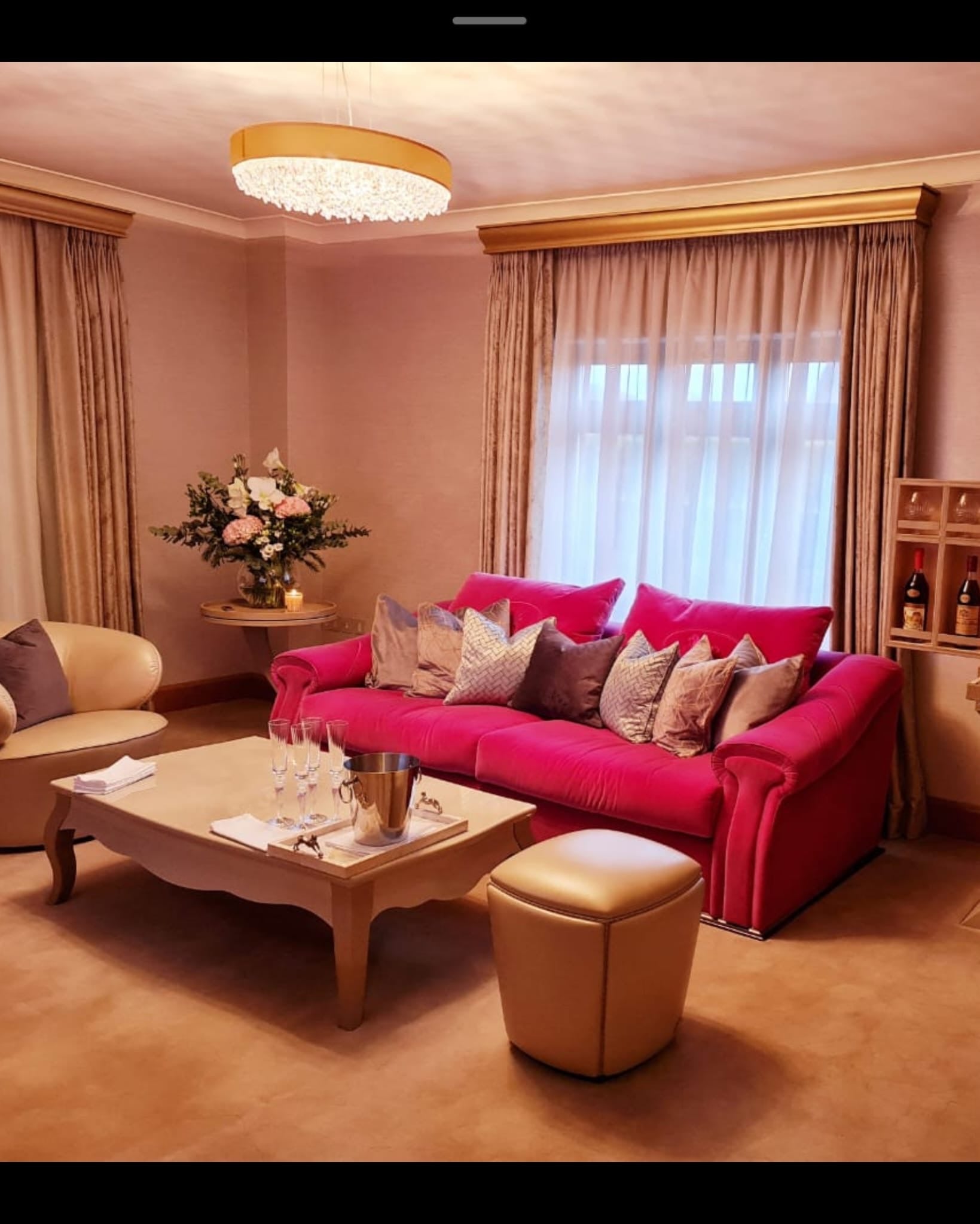 Pink Fendi Casa velvet sofa with plush cushions, modern design, and sleek legs, styled as a statement piece in a contemporary living room.