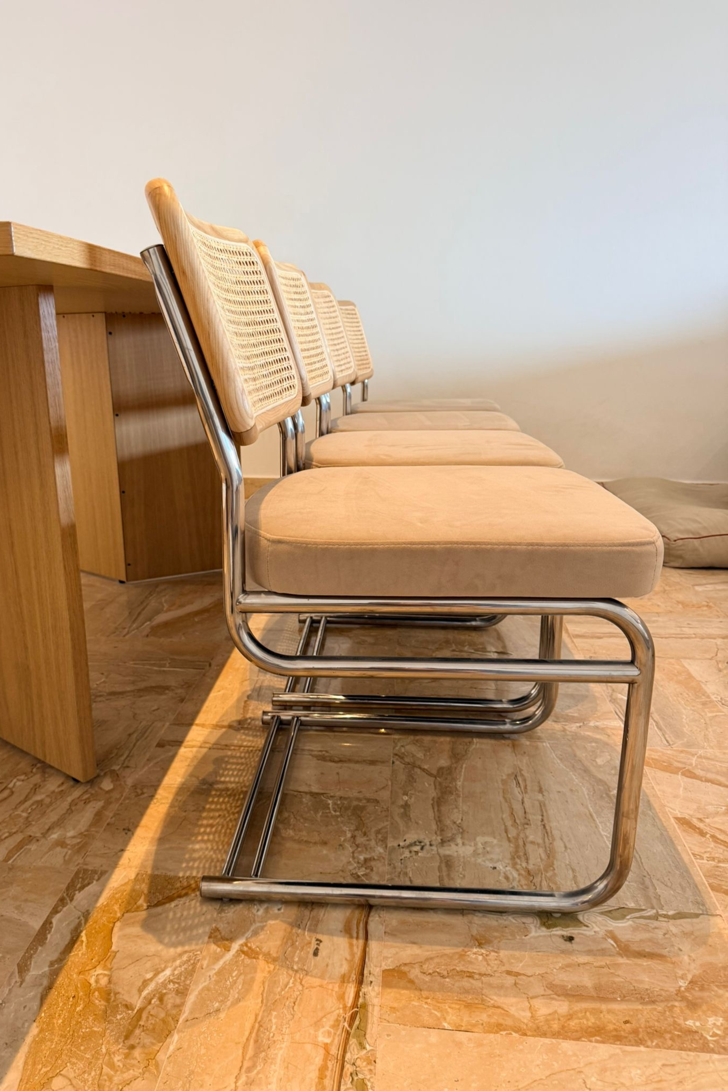 Set of four Bauhaus-style dining chairs by Charlotte Isackson with sleek, minimalist design and wooden legs.