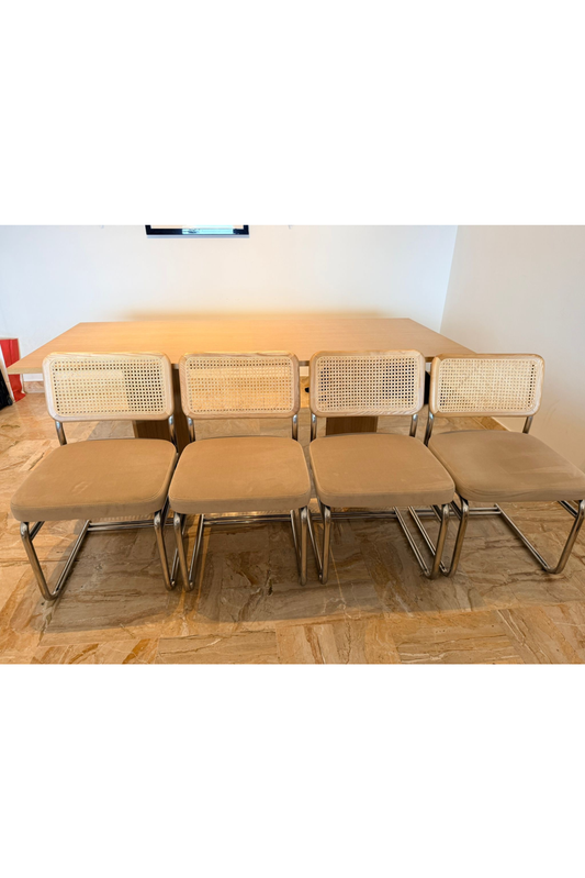 Set of four Bauhaus-style dining chairs by Charlotte Isackson featuring sleek, modern design with wooden frames and minimalist aesthetic.