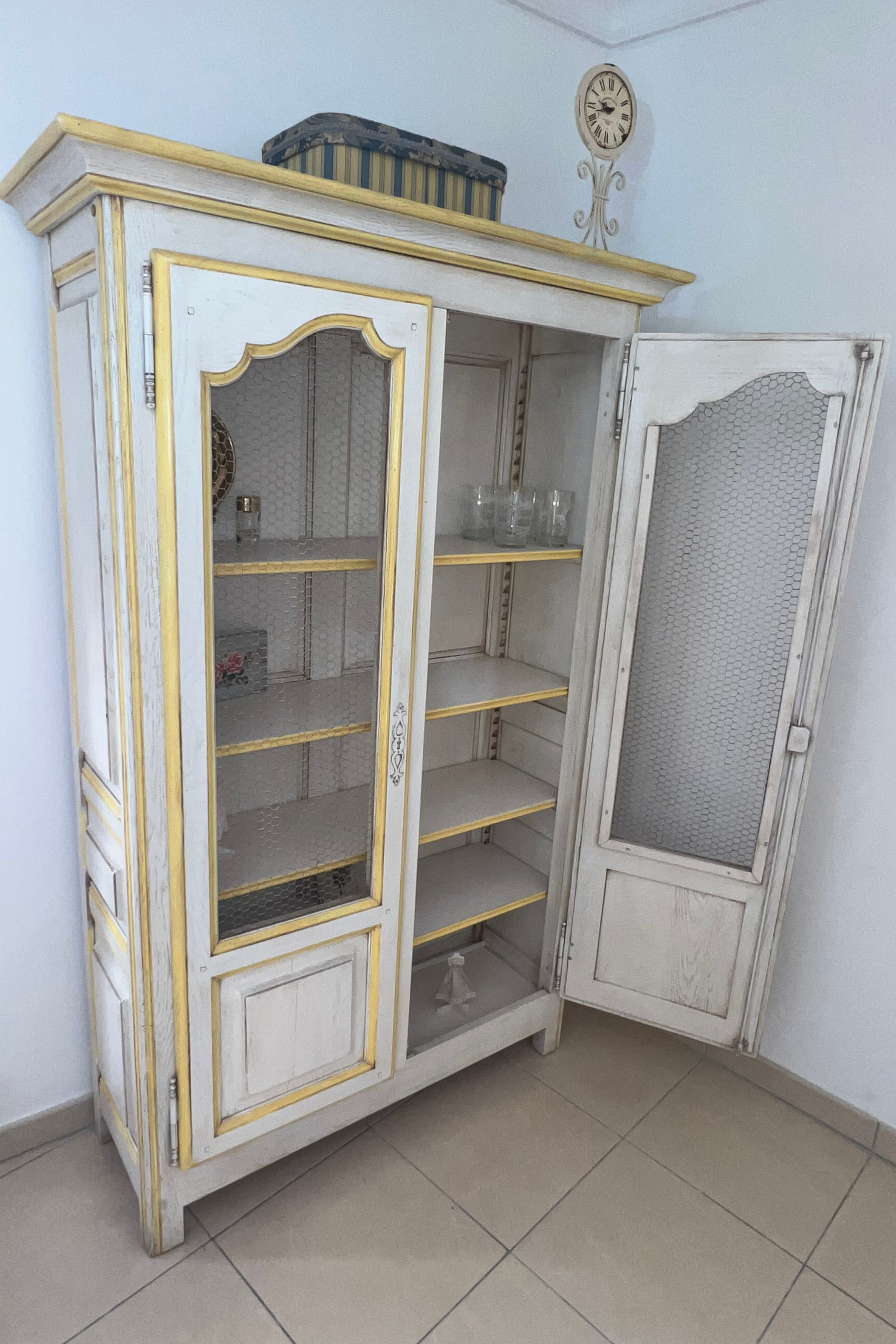 Luca Orrù shabby-chic Provençal display cabinet with glass doors and distressed white finish, ideal for vintage or rustic interiors.