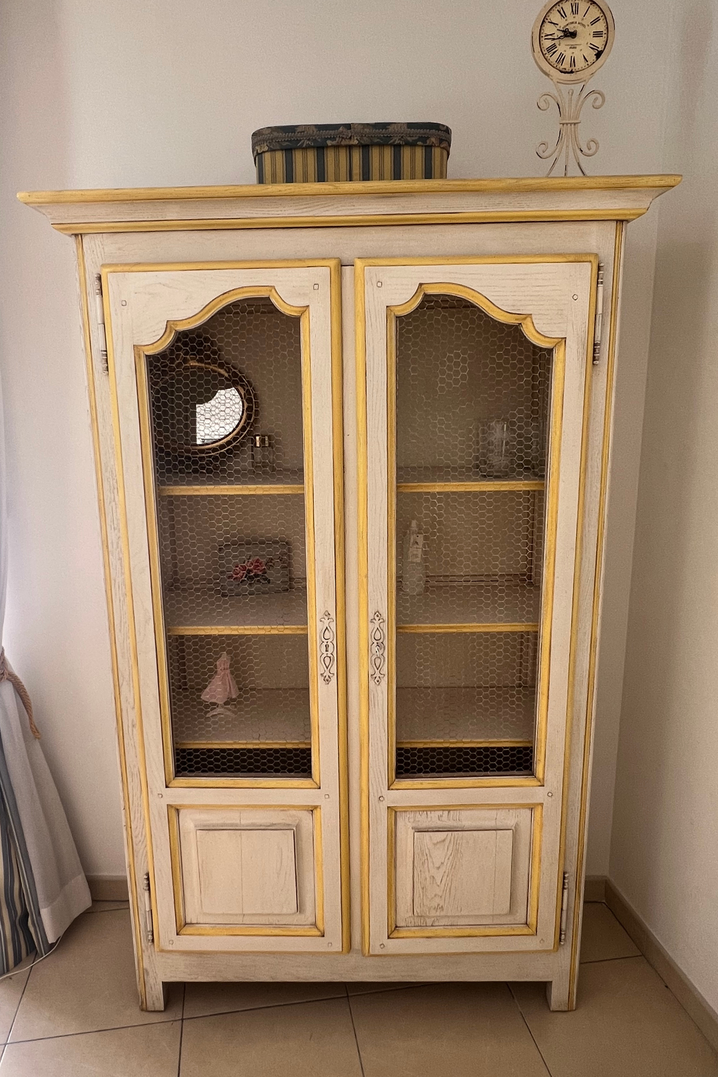 Luca Orrù shabby-chic Provençal-style display cabinet with glass doors and distressed white finish, ideal for showcasing decorative items.