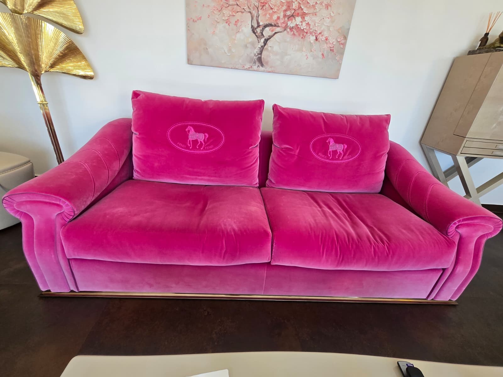 Pink velvet Fendi Casa sofa with modern design, featuring plush cushions and sleek legs, styled in a contemporary living room.