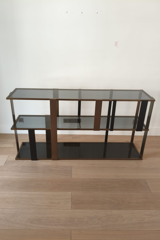 Eichholtz Clio console cabinet with brushed brass finish and smoked glass doors, showcasing sleek modern design.