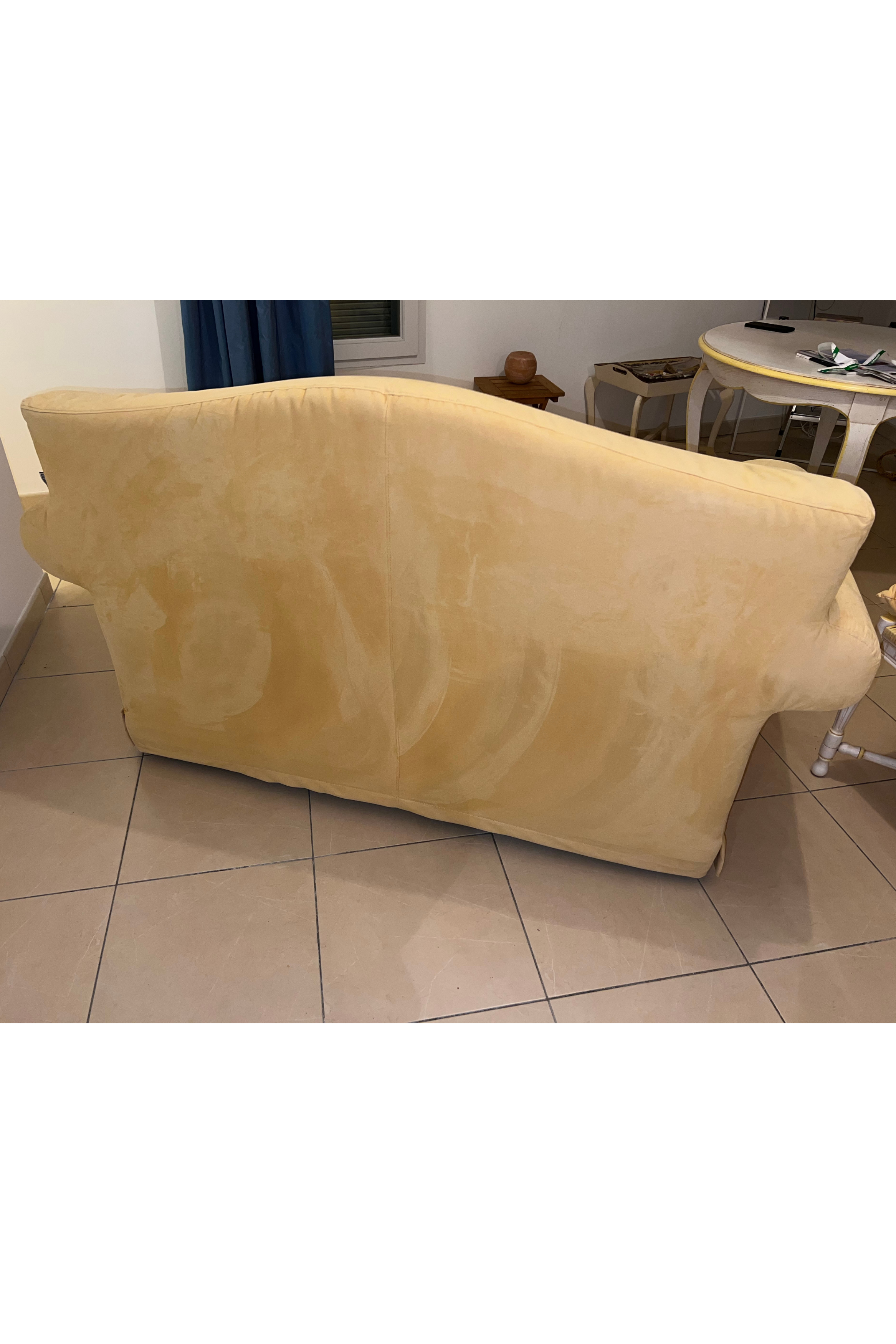 Yellow velvet-style small double sofa bed by Luca Orrù, showcasing its plush fabric and modern design in a cozy living room setting.
