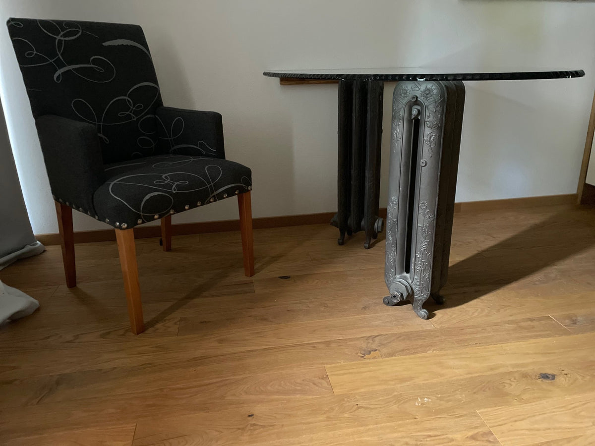 Side view of the glass desk showing the chiselled glass edge and radiator pedestals