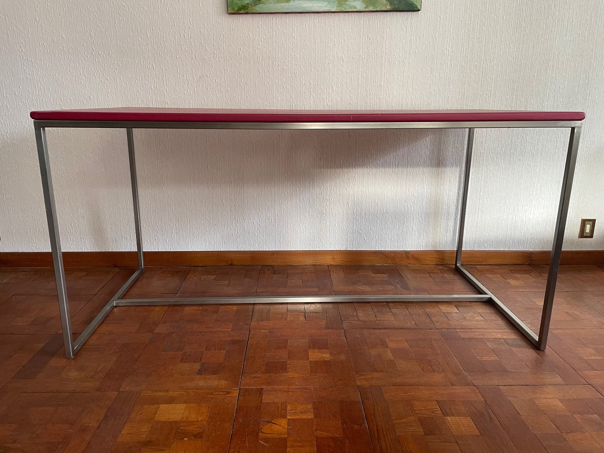 Front view of the red-top desk showing the open stainless steel frame